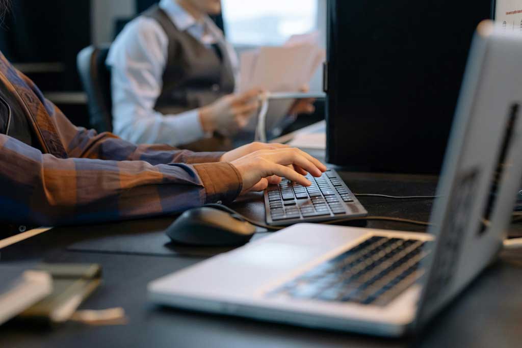 Men Sitting at the Desks in an Office and Using Computers