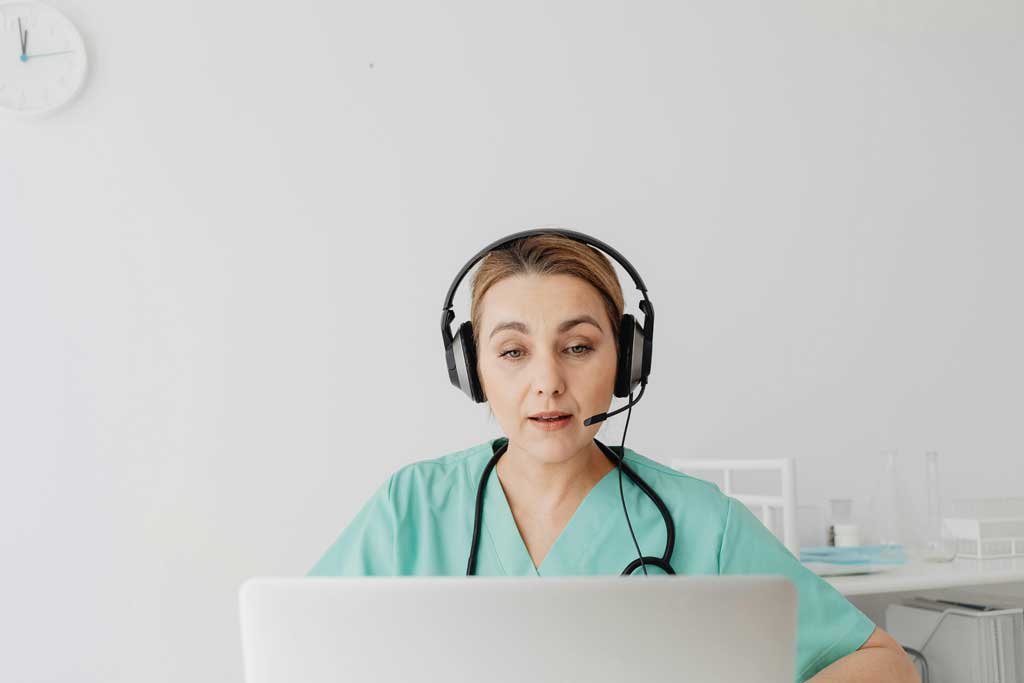 A Woman in Teal Shirt Talking while Wearing Headset