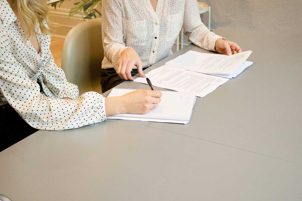 Woman signing on white printer paper