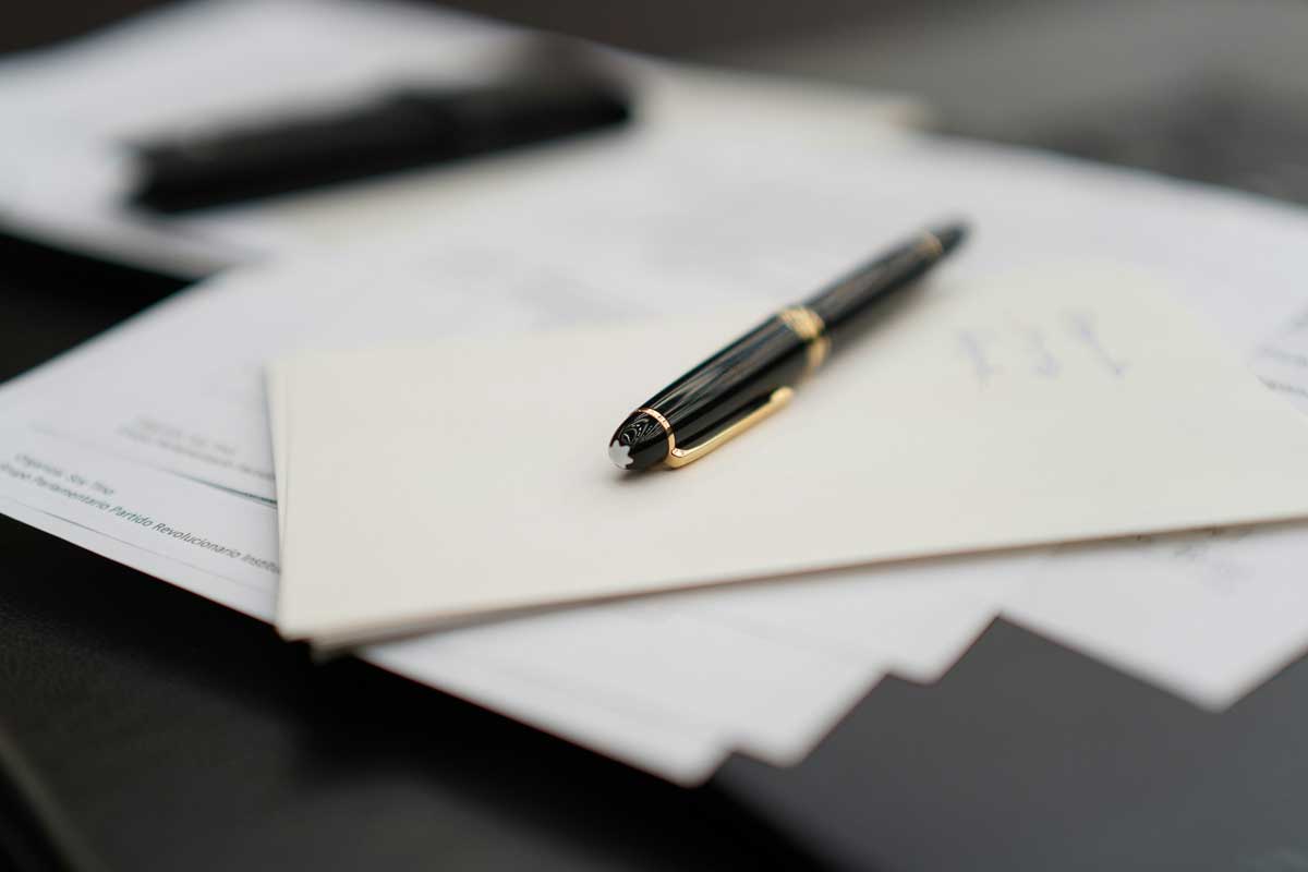 A pen sitting on top of a pile of papers