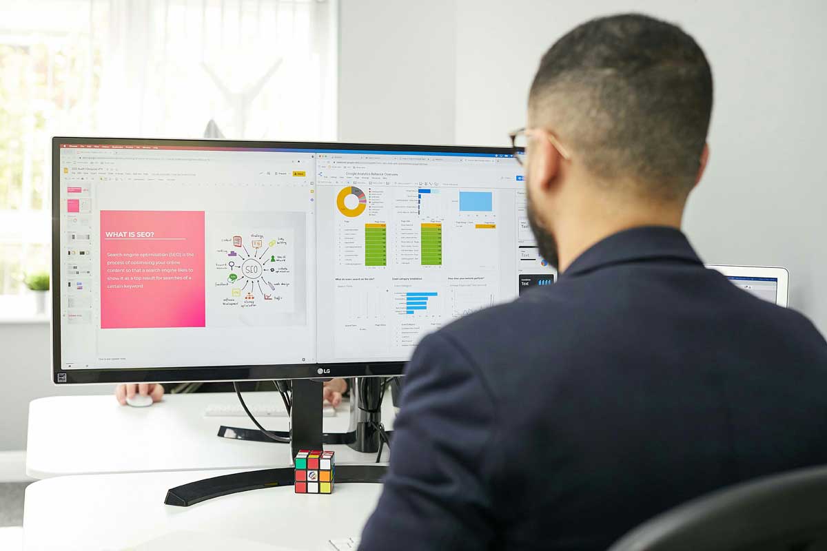 A man sitting at a desk looking at a computer-screen