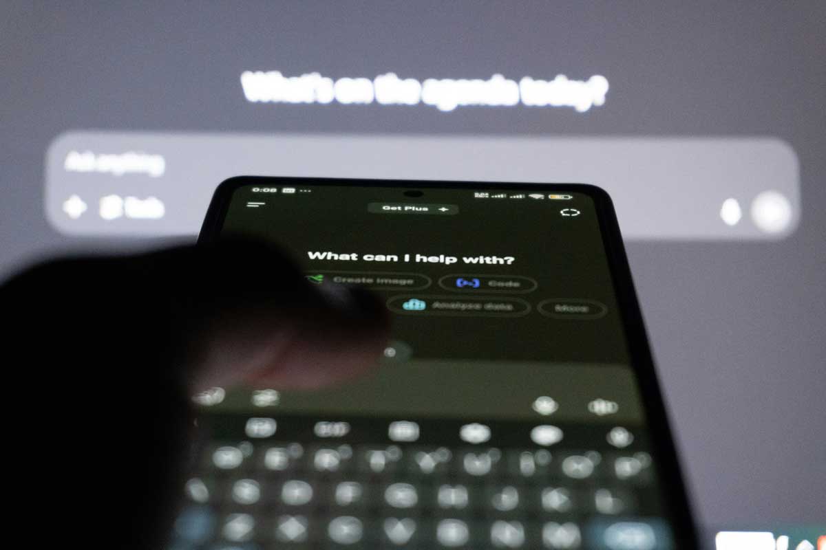Person typing on smartphone with AI  chatbot on screen