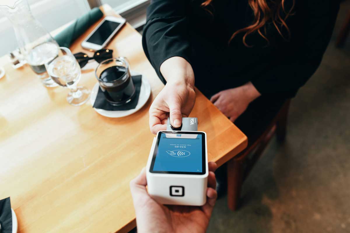 Person holding a modern credit card payment terminal device for secure electronic transactions in business environment