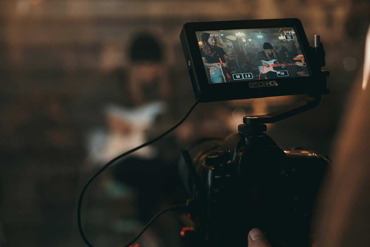 Person captures woman playing guitar from the camera
