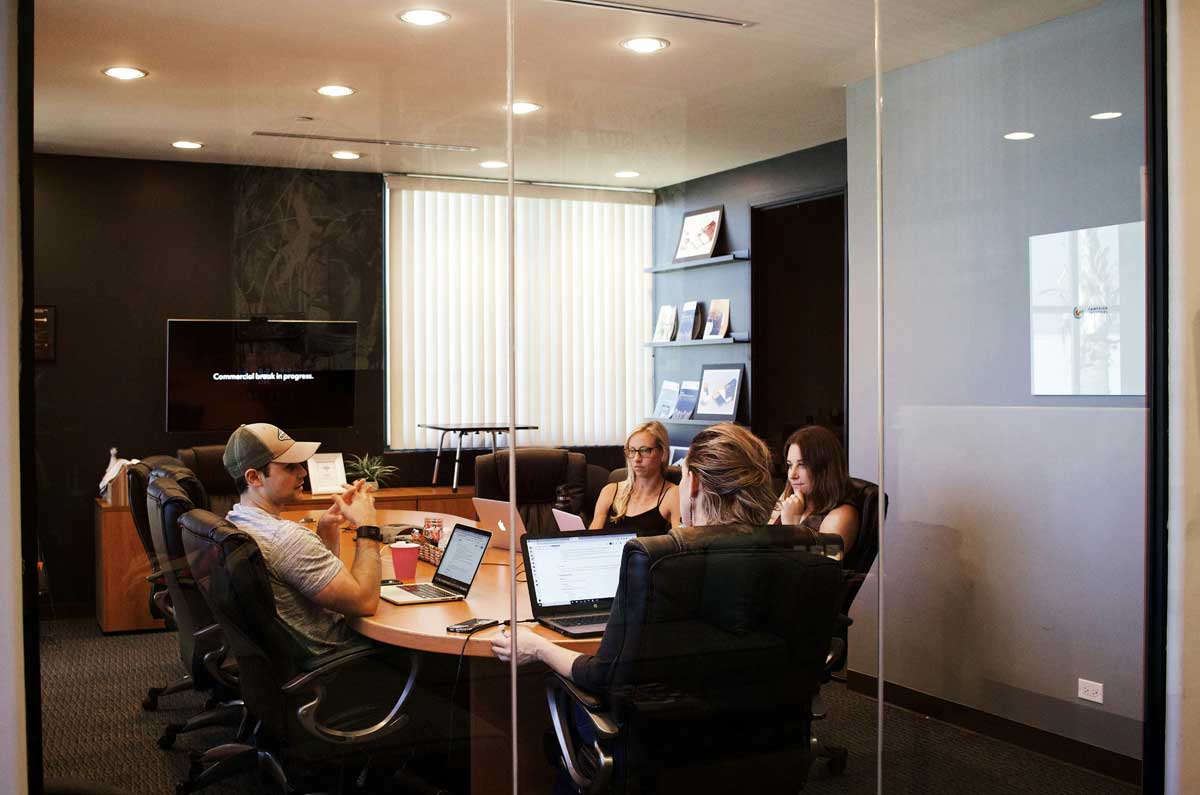People sitting near table with laptop computer