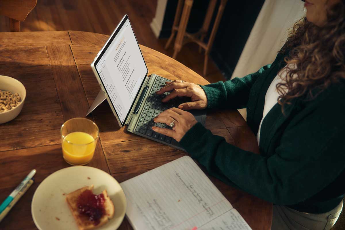 A person is sitting comfortably in a cozy living room, working on a laptop with a router visible on a shelf nearby, illustrating a typical scene of remote work and home internet access. The setting reflects the use of a residential VPN for secure online activities, ensuring a stable connection through a residential IP address.