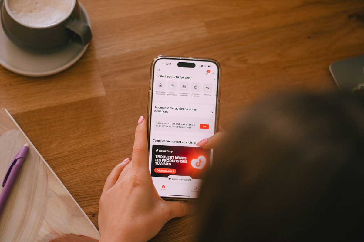 A person is using their phone at a table