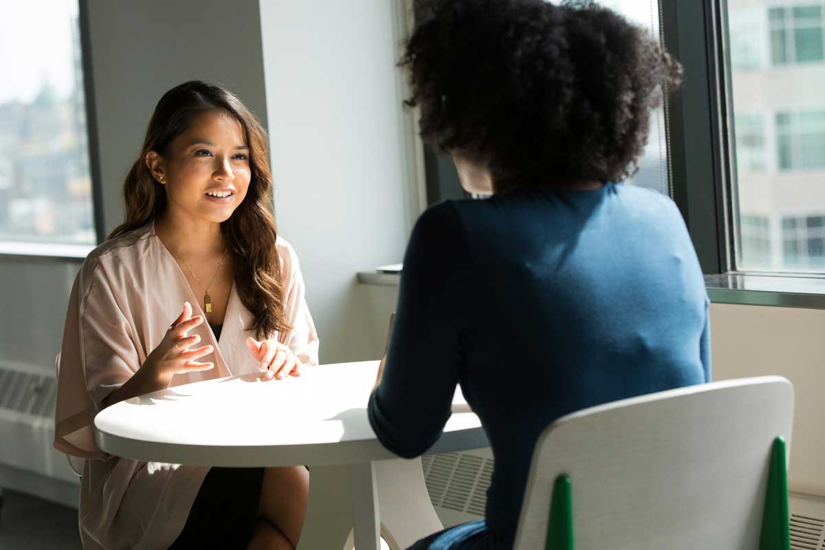 Two women sitting on chair