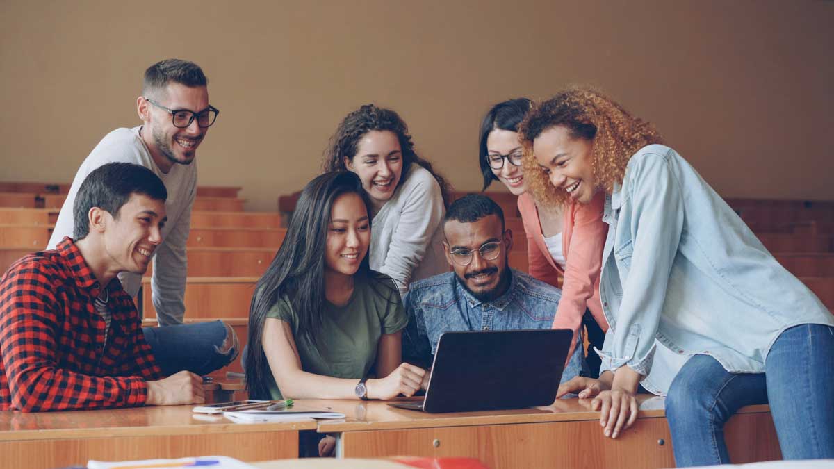 Multiracial team of students is working with laptop