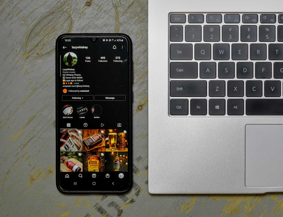 Phone with social media icons next to a laptop