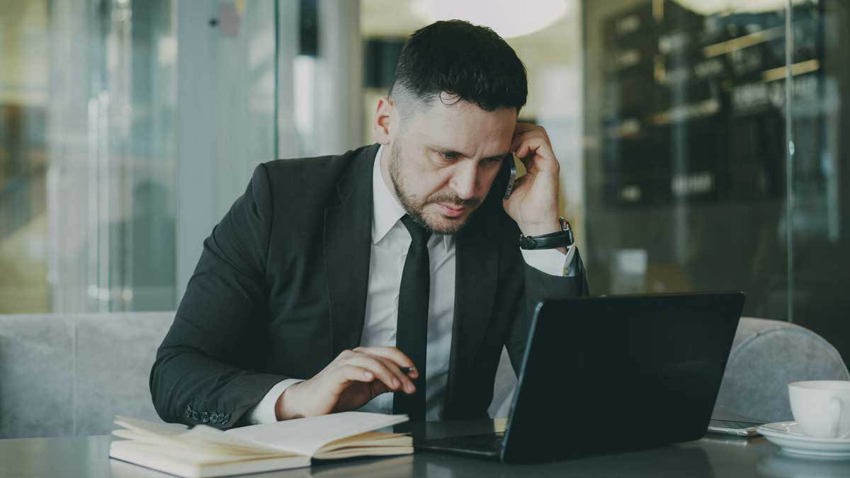 Man in suit working on laptop at a table