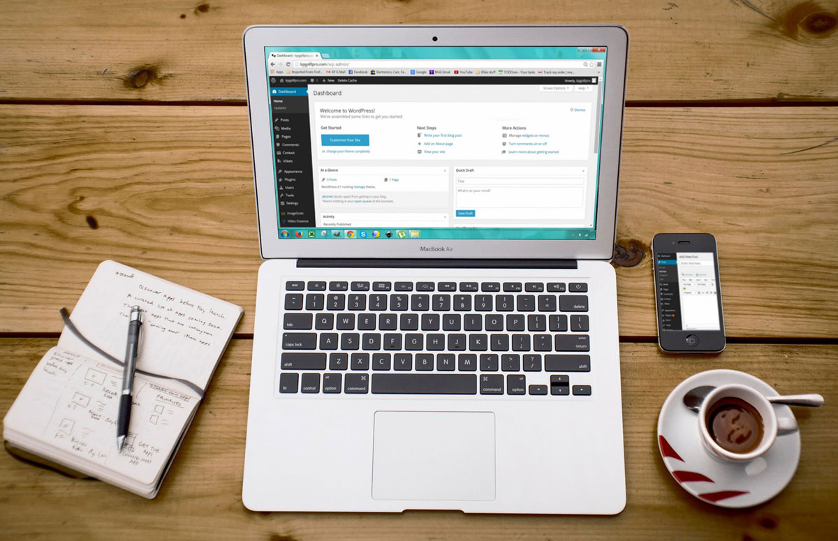 A cozy home office scene with a laptop, notebook, smartphone, and coffee, perfect for productivity