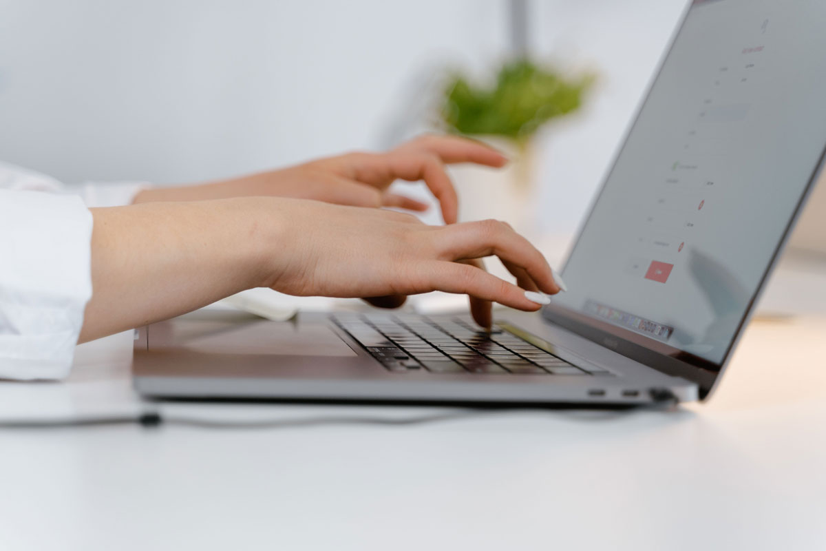 Hands typing on a laptop keyboard, ideal for concepts of remote work and technology