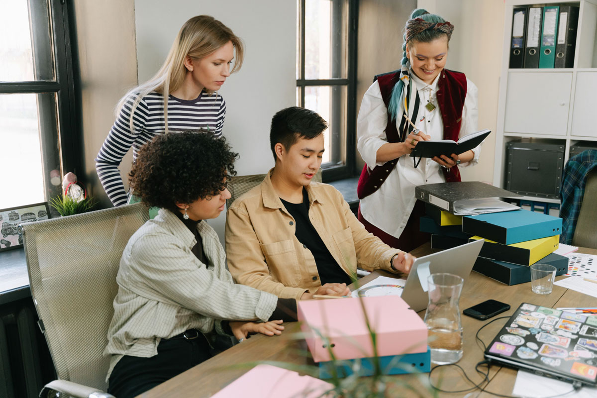 A group of young professionals engaging in a collaborative meeting in a modern office setting