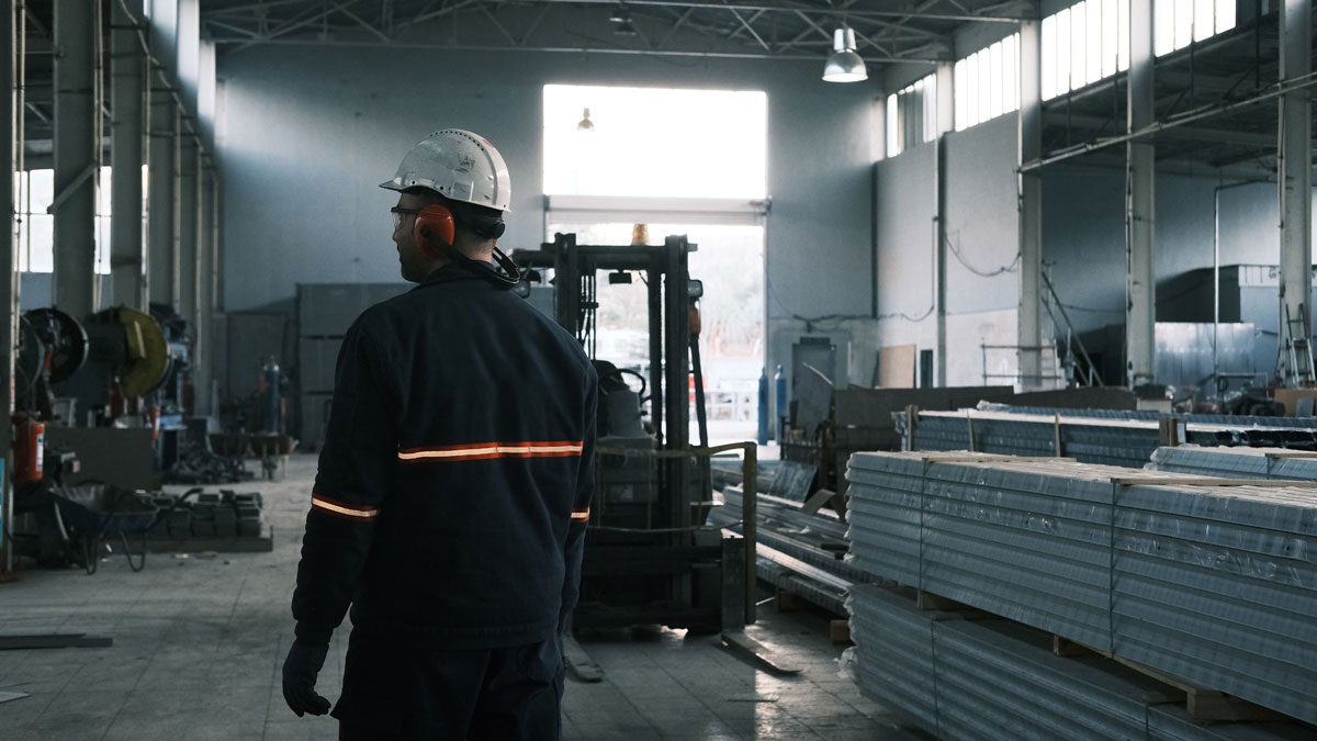 A worker in protective gear supervises operations