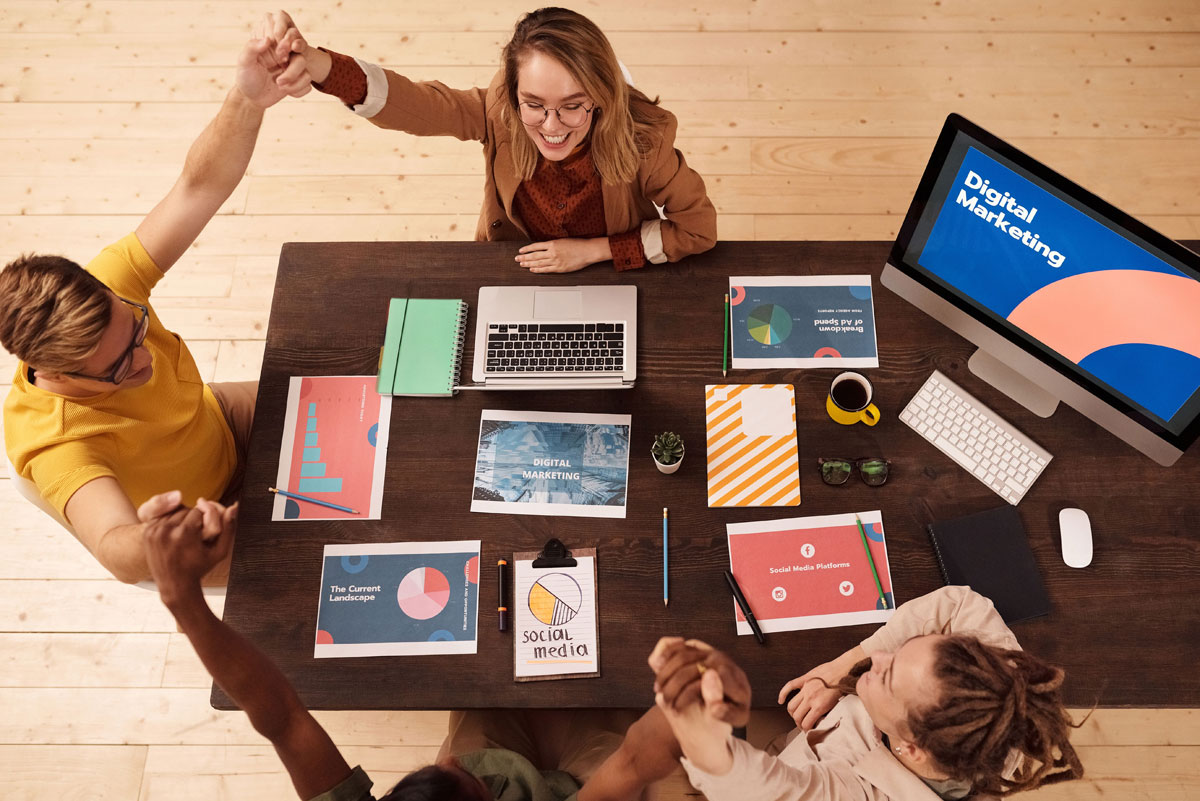 Colleagues celebrating success in a modern digital marketing office with teamwork and collaboration