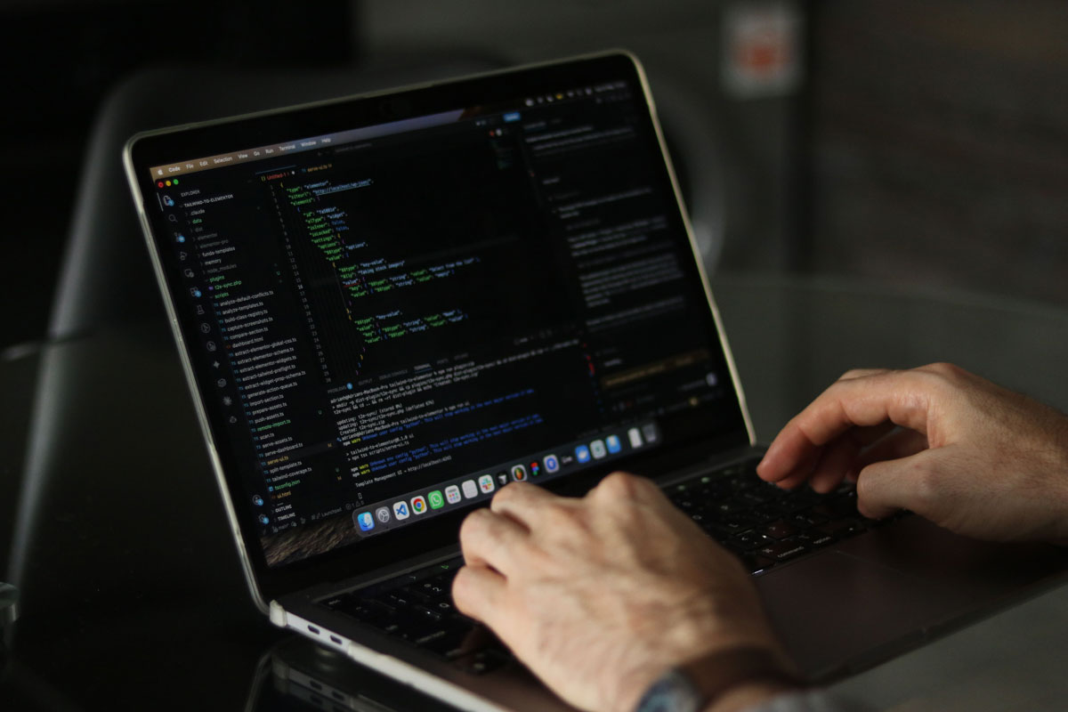 Close-up of hands coding on a laptop, focusing on programming productivity