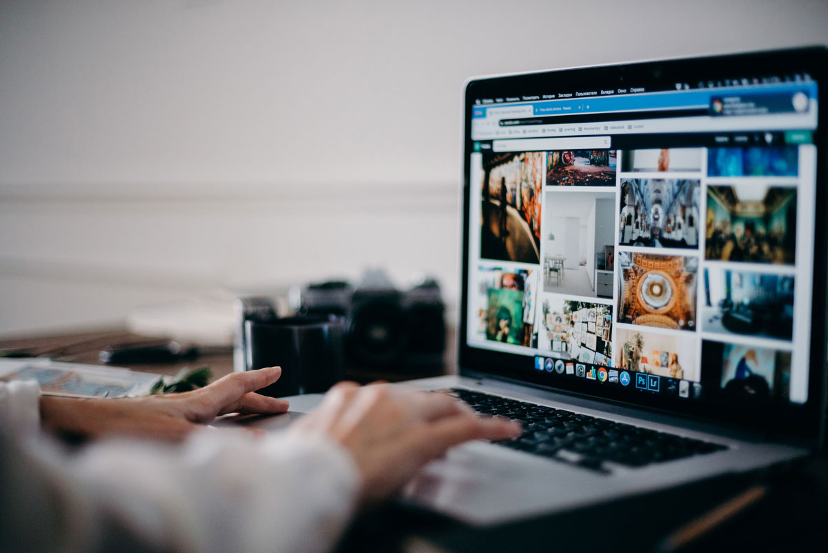 Close-up of hands using laptop for image searching and browsing digital photo gallery