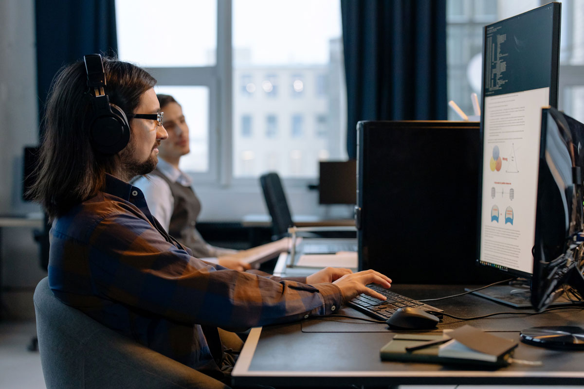 Two programmers working together with focus on coding in a modern, tech-savvy office environmen