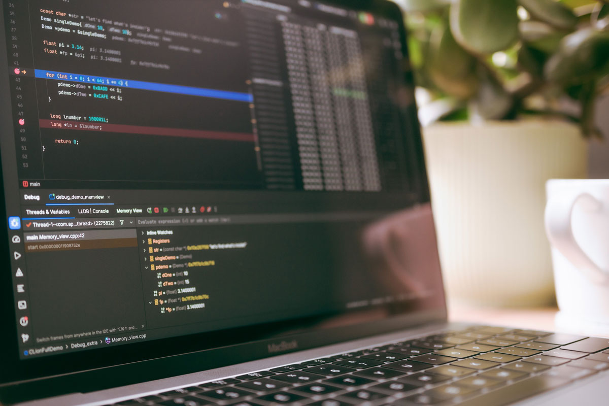 A laptop screen showing programming code and debugging tools