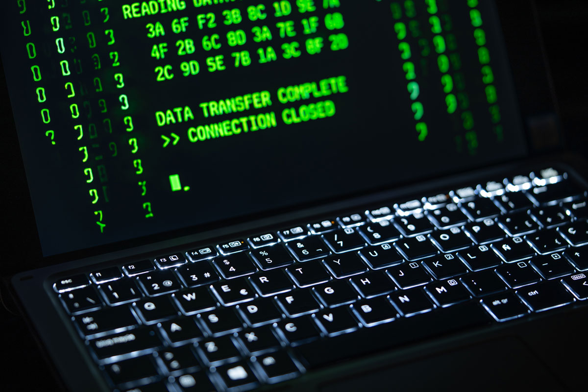 Close-up of a laptop screen displaying green code text.